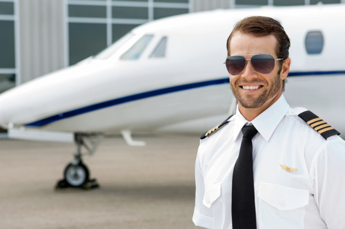 Confident pilot smiling in front of private jet; Shutterstock ID 171215267; PO: today.com